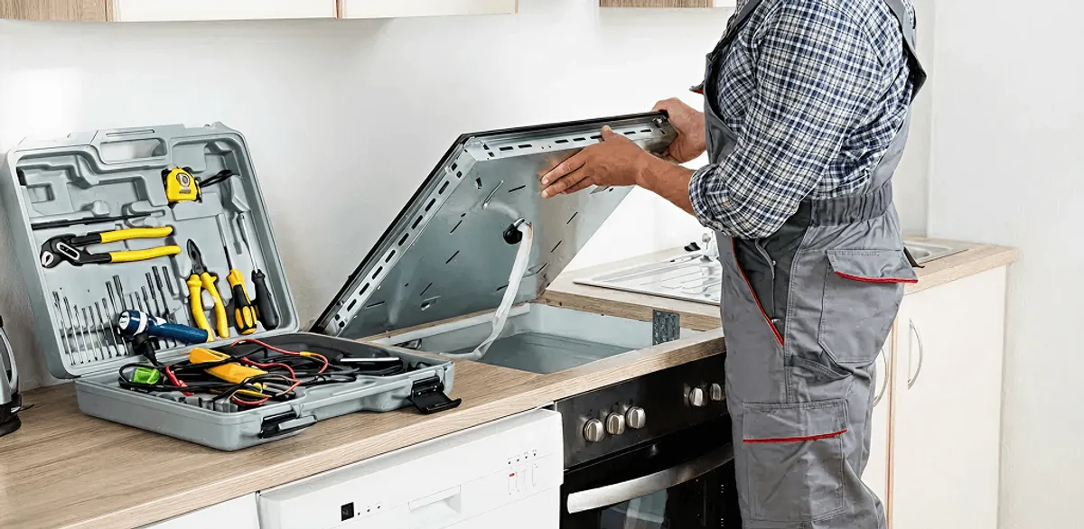 Handyman repairing a cooktop and checking wiring connections in Indianapolis, IN